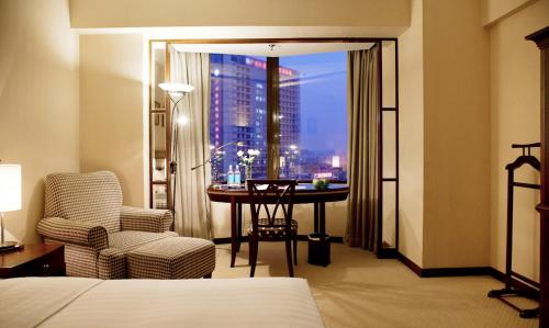 广州广州珀丽酒店(广交会期间提供接驳巴士至广交会展馆）的配有一张床、一张书桌和一扇窗户的酒店客房