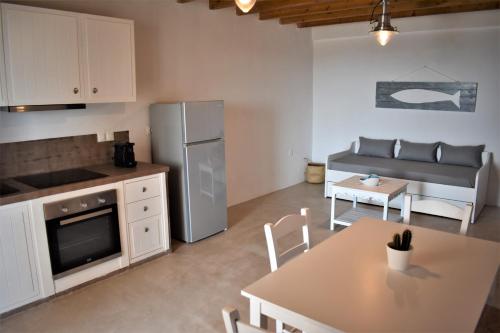 塞里福斯Arsinoi Apartments的厨房以及带桌子和冰箱的客厅。