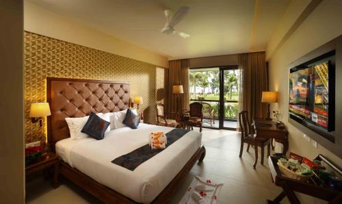 阿勒皮Uday Backwater Resort的酒店客房设有一张大床和一台电视。