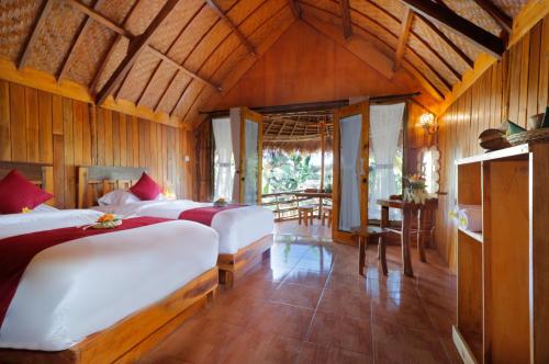 珀尼达岛The Tamban Jukung的一间卧室配有两张床和一张桌子
