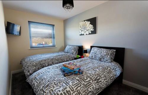 特雷杜尔Valley Lodge的一间卧室配有一张床、一张床和一个窗户。