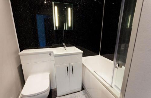 特雷杜尔Valley Lodge的浴室配有卫生间、盥洗盆和浴缸。