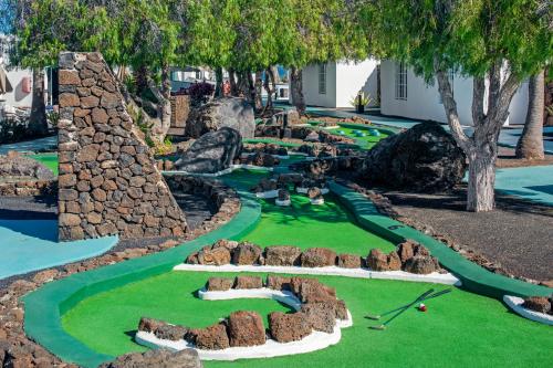 卡门港兰萨罗特鹦鹉螺公寓式酒店的一座拥有树木和岩石的度假村内的迷你高尔夫球场