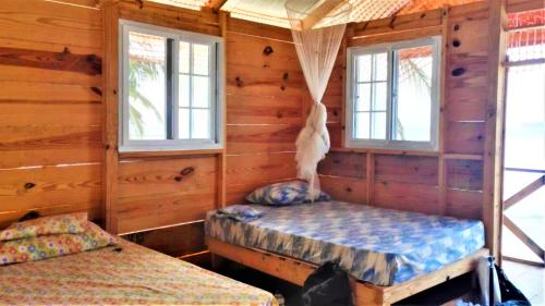El PorvenirEnjoy San Blas - Isla Diablo (Guna Yala)的小木屋内一间卧室,配有两张床