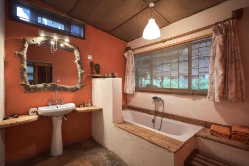 育空河Hillside Retreat – Africa Amini Life的浴室配有盥洗盆和浴缸。