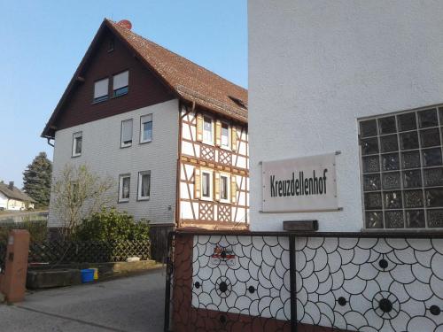 HembachKreuzdellenhof Ferienzimmer的房屋旁的栅栏上带有标志的建筑物