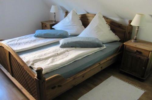 巴特法灵博斯特尔Weissewolke的卧室内的一张带枕头的木床