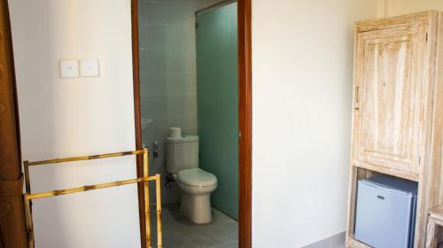 坎古Dana Homestay的一间带卫生间和绿色墙壁的浴室