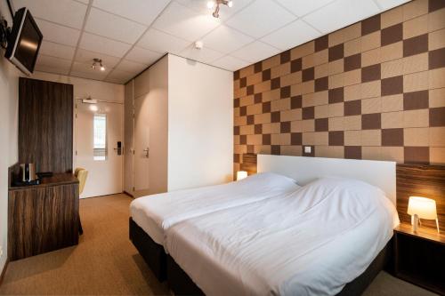 巴勒纳绍布鲁尔斯运动酒店的一间卧室配有一张床和一个 ⁇ 板墙