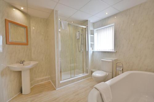布莱克浦Stuart hotel的带淋浴卫生间和盥洗盆的浴室