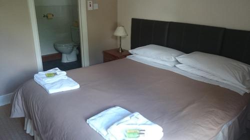 斯旺西The New Swan Hotel的卧室配有带毛巾的大型白色床