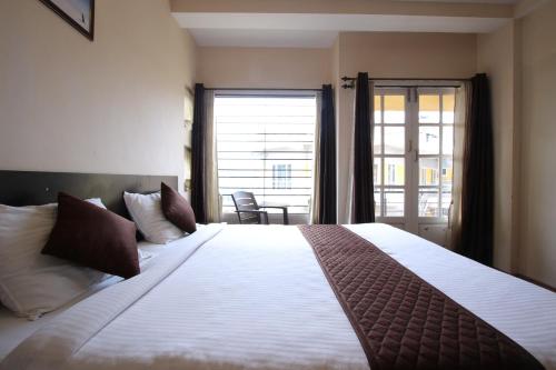 乌提山边公寓的一间卧室设有一张大床和大窗户