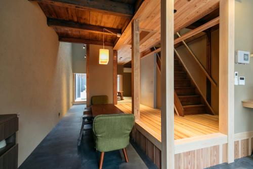 京都MACHIYADO 京都南禅寺道的客房设有木桌和绿色椅子。