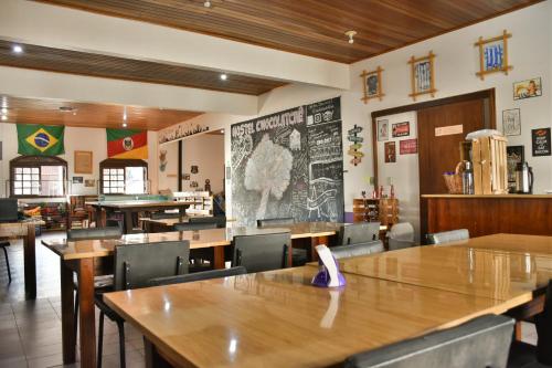 格拉玛多Hostel Chocolatchê的用餐室配有木桌和椅子