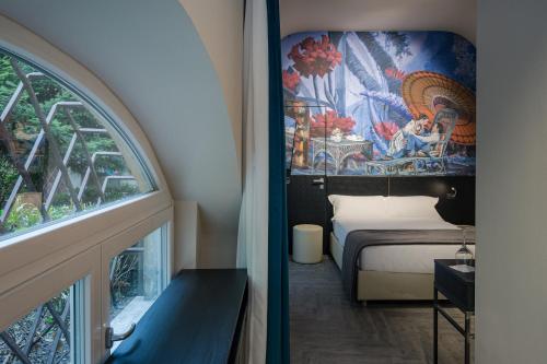维罗纳Theatrum Rooms and Suite的客房设有床和带壁画的窗户。