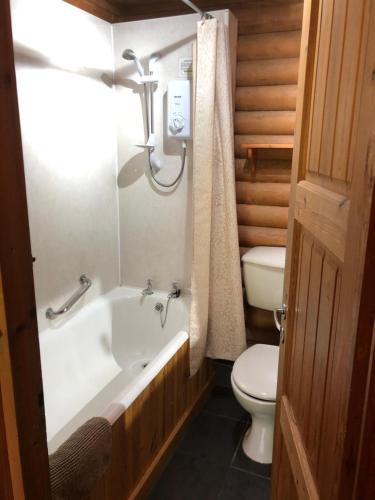 伊文格瑞Highgarry Lodges的浴室配有白色浴缸和卫生间。