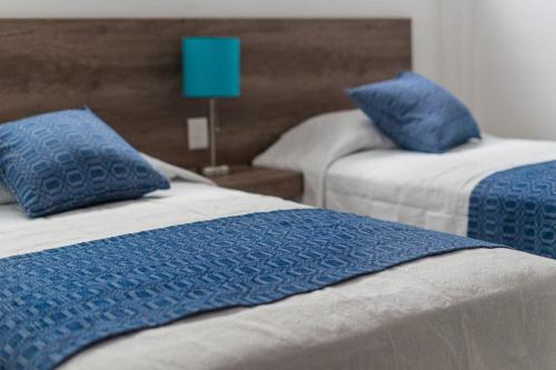 瓦哈卡市JUUB @ THE SOUL OF OAXACA (R3)的两张带蓝色枕头的床