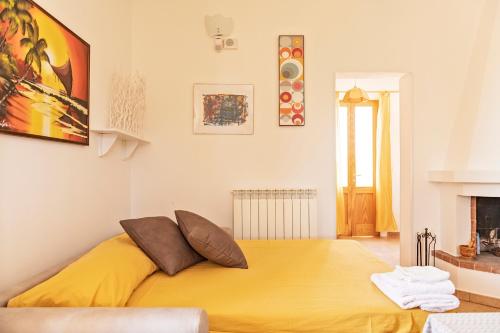 加利波利Villa Nanni的带壁炉的客房内一张黄色的大床