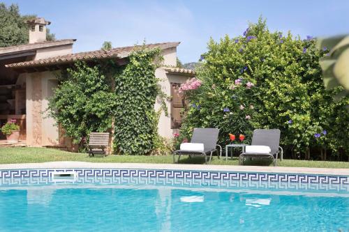 索列尔坎夸特雷庄园酒店的一个带两把椅子的游泳池以及一座房子