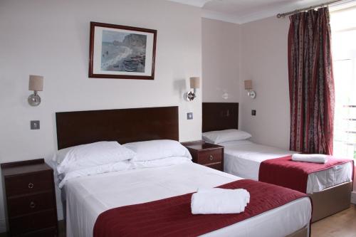 布莱顿霍夫Ambassador Hotel的酒店客房设有两张床和窗户。