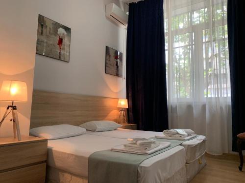 第比利斯Piccolo Casa Bella Hotel的一间卧室设有两张床和大窗户