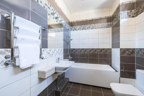 尤尔马拉Black Pearl Apartments的带浴缸水槽和卫生间的浴室