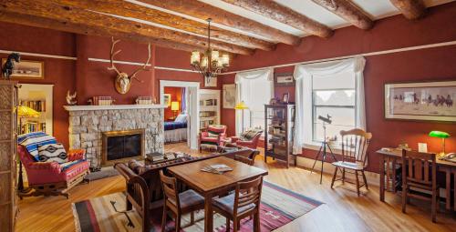 CimarronCasa del Gavilan Historic Inn的客厅配有桌子和壁炉