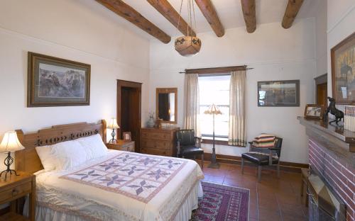 CimarronCasa del Gavilan Historic Inn的一间卧室设有一张大床和一个壁炉