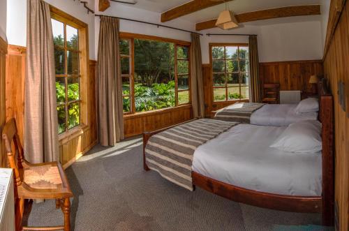 PueloAndes Lodge, Puelo Patagonia的带窗户的客房内的两张床