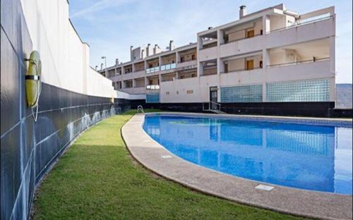 比卡尔Apartamentos Deluxe Roquetas de Mar con Golf y Piscina Climatizada, Parking privado的大楼前的游泳池