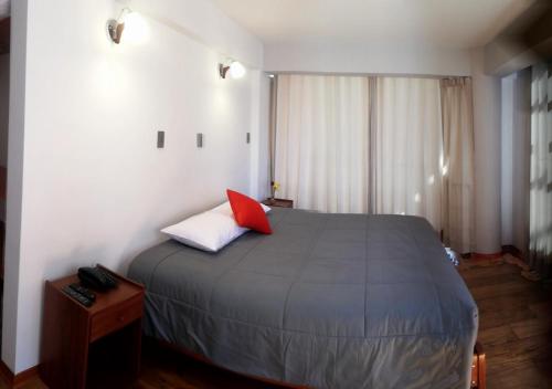 库斯科Real House Cusco的一间卧室配有一张红色枕头的床