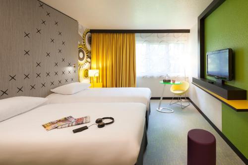 贝桑松贝桑松诺富特酒店的酒店客房设有两张床和电视。
