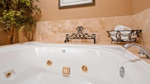 格伦多拉Best Western Route 66 Glendora Inn的浴室配有白色浴缸及长凳