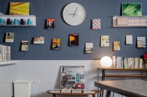 宜兰市飞包客青年旅店的墙上挂着时钟、桌子和书