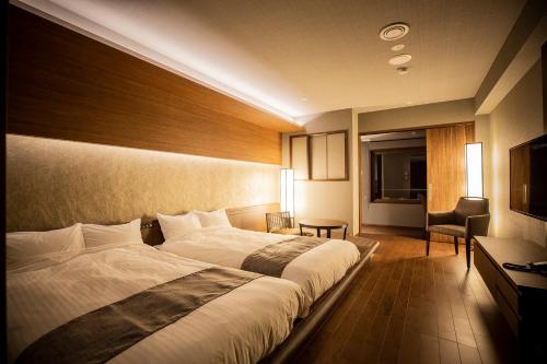 函馆汤之川渚太子酒店的酒店客房带一张大床和一把椅子