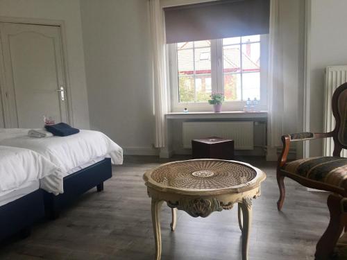 WielsbekeMaison Blanche的一间卧室配有一张床、一张桌子和一个窗户。