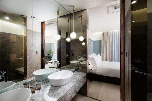 仁川市公园海洋酒店的一间带两个盥洗盆和一张床的浴室