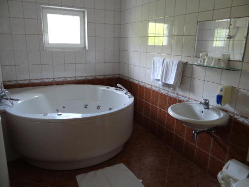 采列河卡霍特宾馆的一间带大浴缸和水槽的浴室