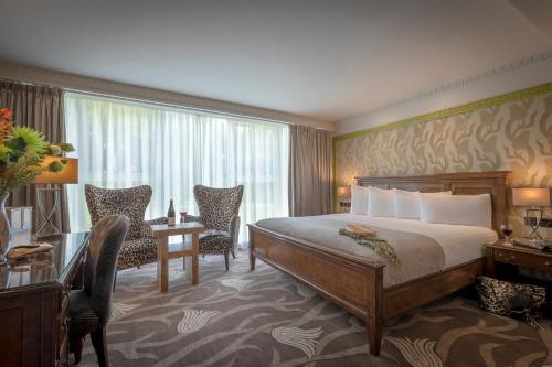 德罗赫达Boyne Valley Hotel - Bed & Breakfast Only的酒店客房,配有一张床、一张桌子和椅子