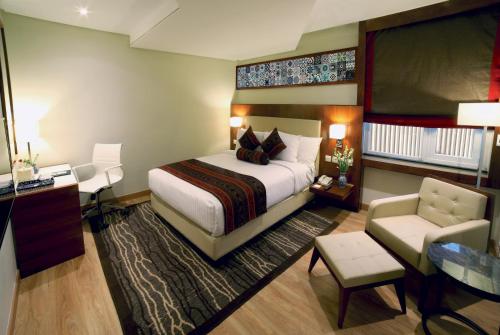 木尔坦Avari Xpress Multan的配有一张床和一把椅子的酒店客房