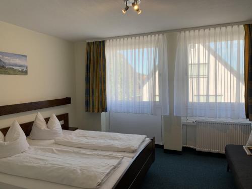 莫斯巴赫Hotel Lindenhof的酒店客房设有两张床和窗户。