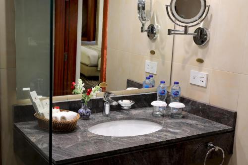 木尔坦Avari Xpress Multan的浴室的柜台设有水槽和镜子