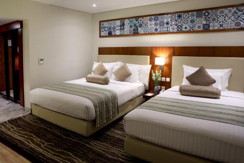 木尔坦Avari Boutique Multan的一间酒店客房,房间内设有两张床