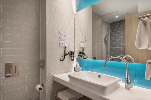 锡根锡根快捷假日酒店的一间带水槽和镜子的浴室