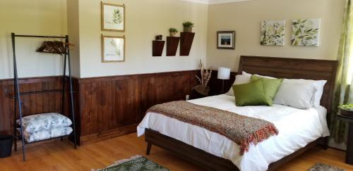 特里尼蒂Trinity Guest House的一间卧室配有带白色床单和绿色枕头的床。