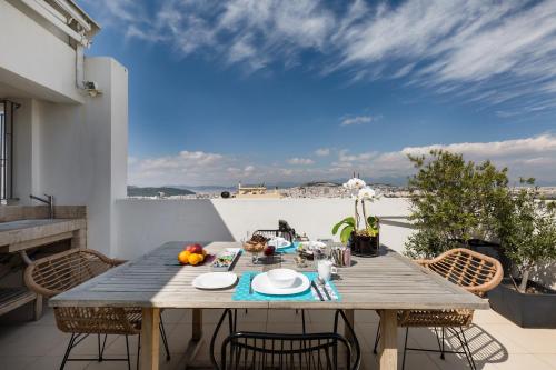雅典GB Athens View Luxury Suite的房屋阳台的木桌