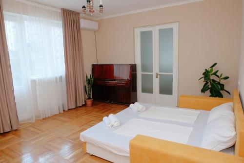 第比利斯Keti&Tatia Sisters Apartment - near Old and Central Tbilisi的卧室配有白色的床和钢琴