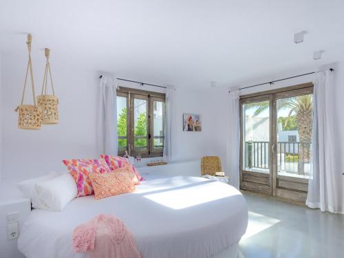 圣埃乌拉利亚阿格马萨别墅的白色卧室设有一张大床和一个阳台