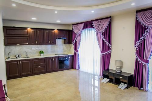 乌曼岛Palace的厨房配有紫色窗帘和水槽