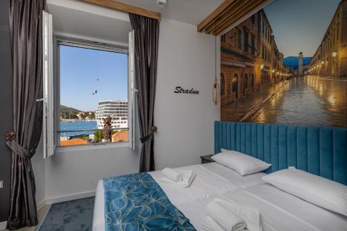 杜布罗夫尼克Apartments and Rooms Villa Naida的一张位于带大窗户的房间内的床铺